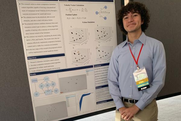 Leonardo Poole stands next to his research poster